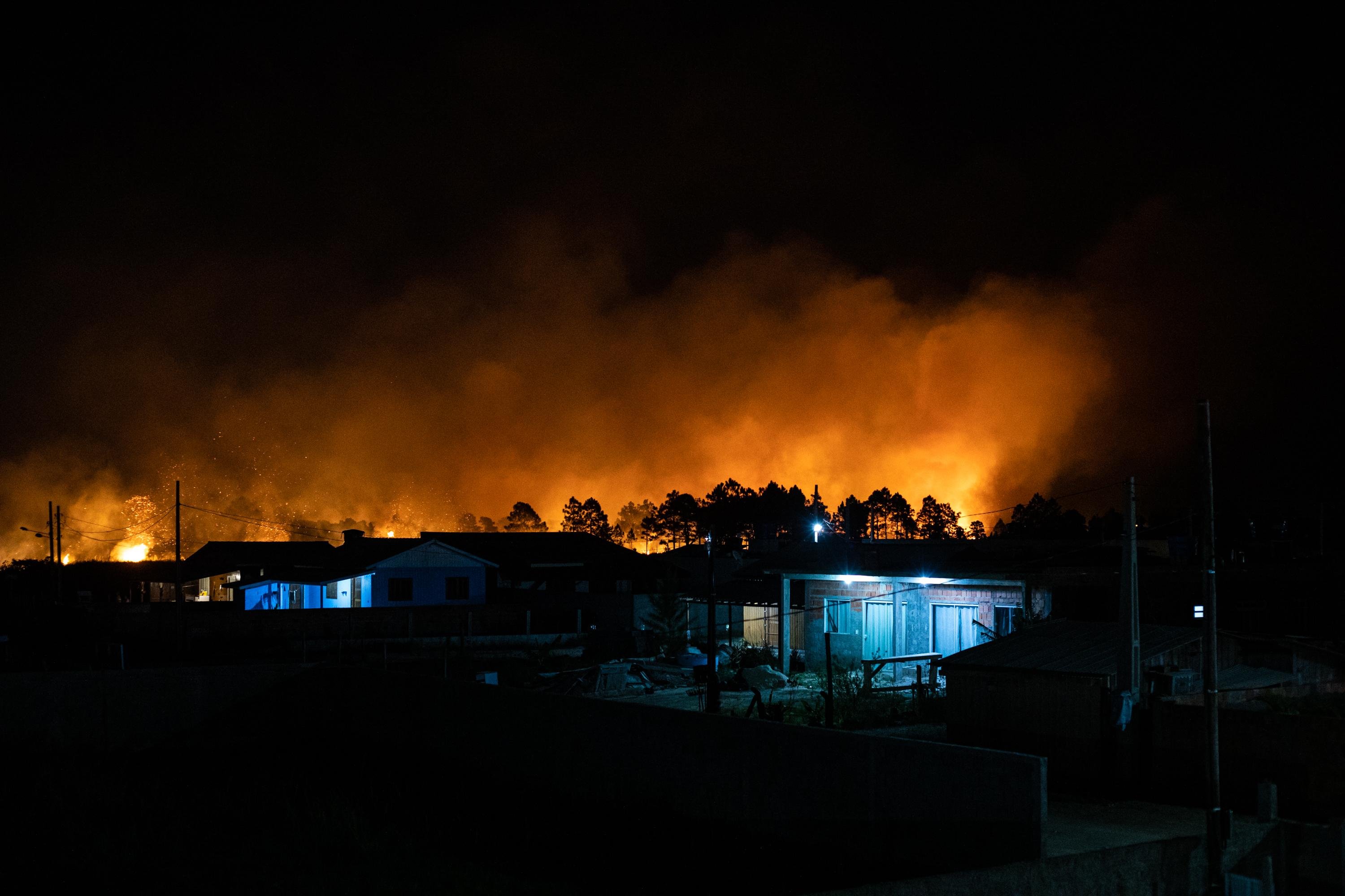 Moradores foram retirados das suas casas enquanto equipes ainda tentam, sem sucesso, controlar as chamas