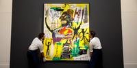 Funcionários da Sotheby's mostram 'Pryos', obra de Jean Michel Basquiat
