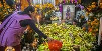 Mulher oferece frutas em Dia dos Mortos na vila de Santa Fé de la Laguna, Quiroga