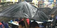 Alunos utilizaram um guarda-chuva para se proteger das coteiras da sala de aula