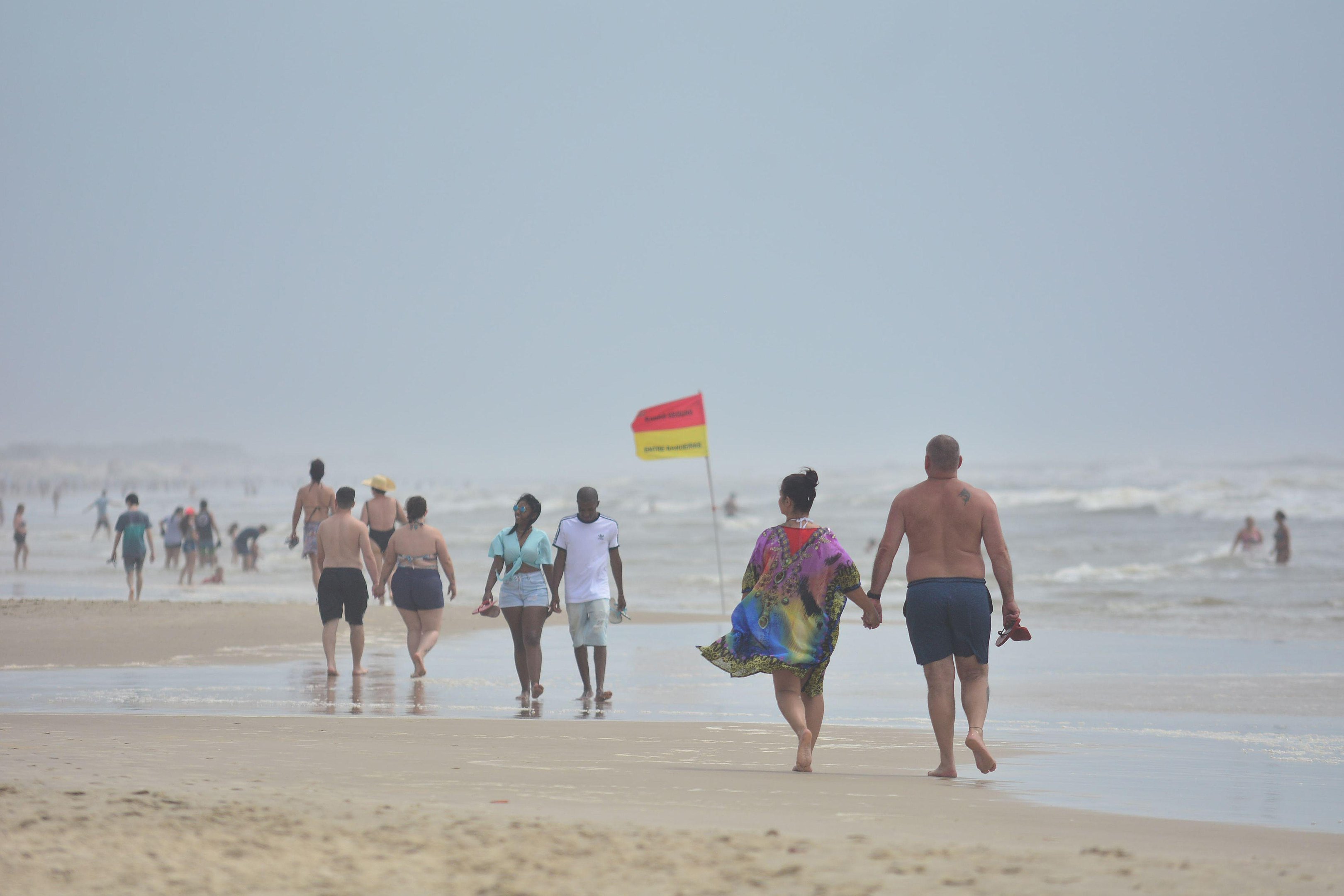 Veranistas aproveitaram s&aacute;bado nublado para caminhar na beira da praia em Imb&eacute;