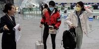 Passageiros usam máscaras no aeroporto internacional de Pequim