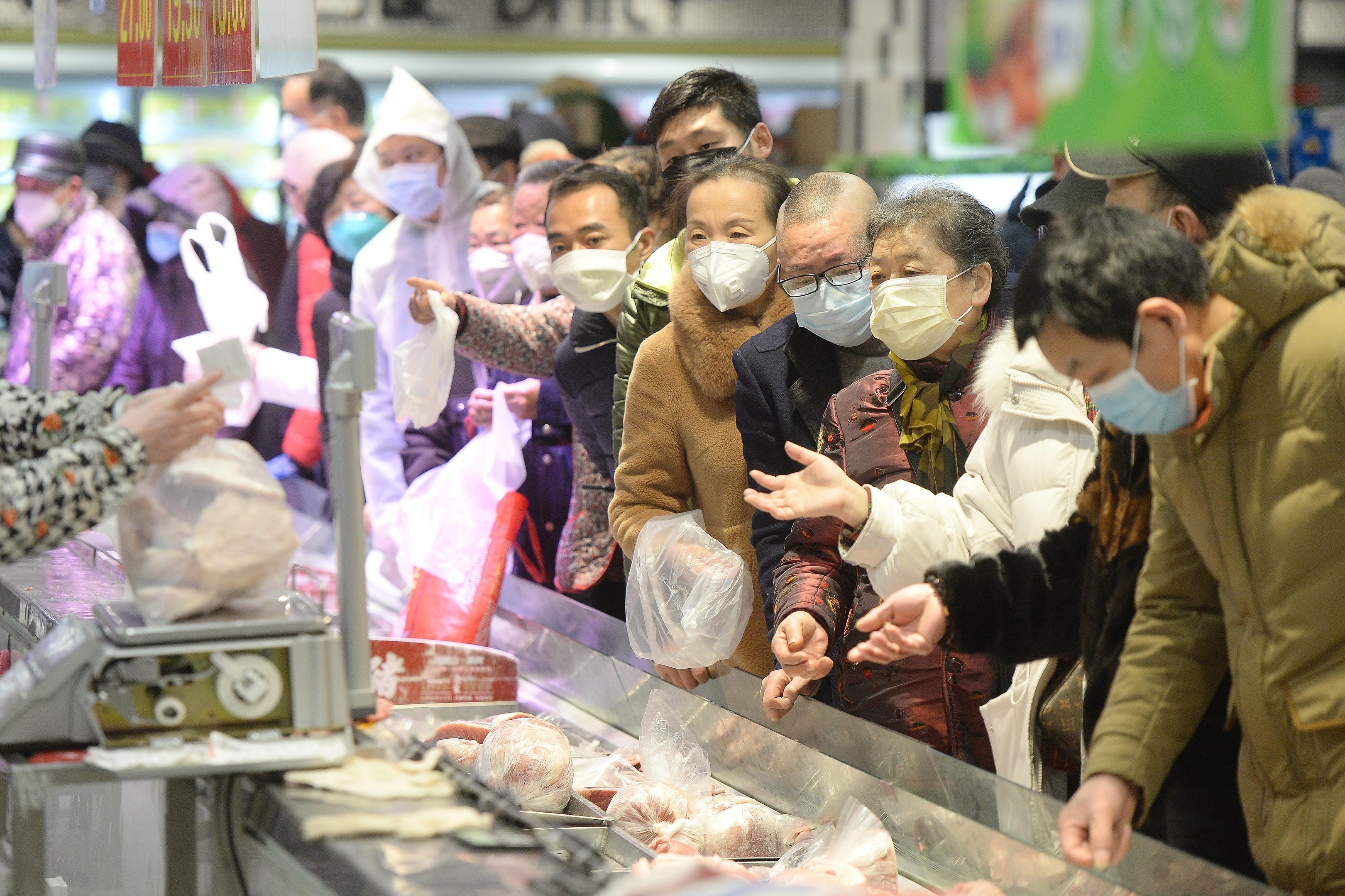 Pessoas usam m&aacute;scaras para fazer compras em Wuhan