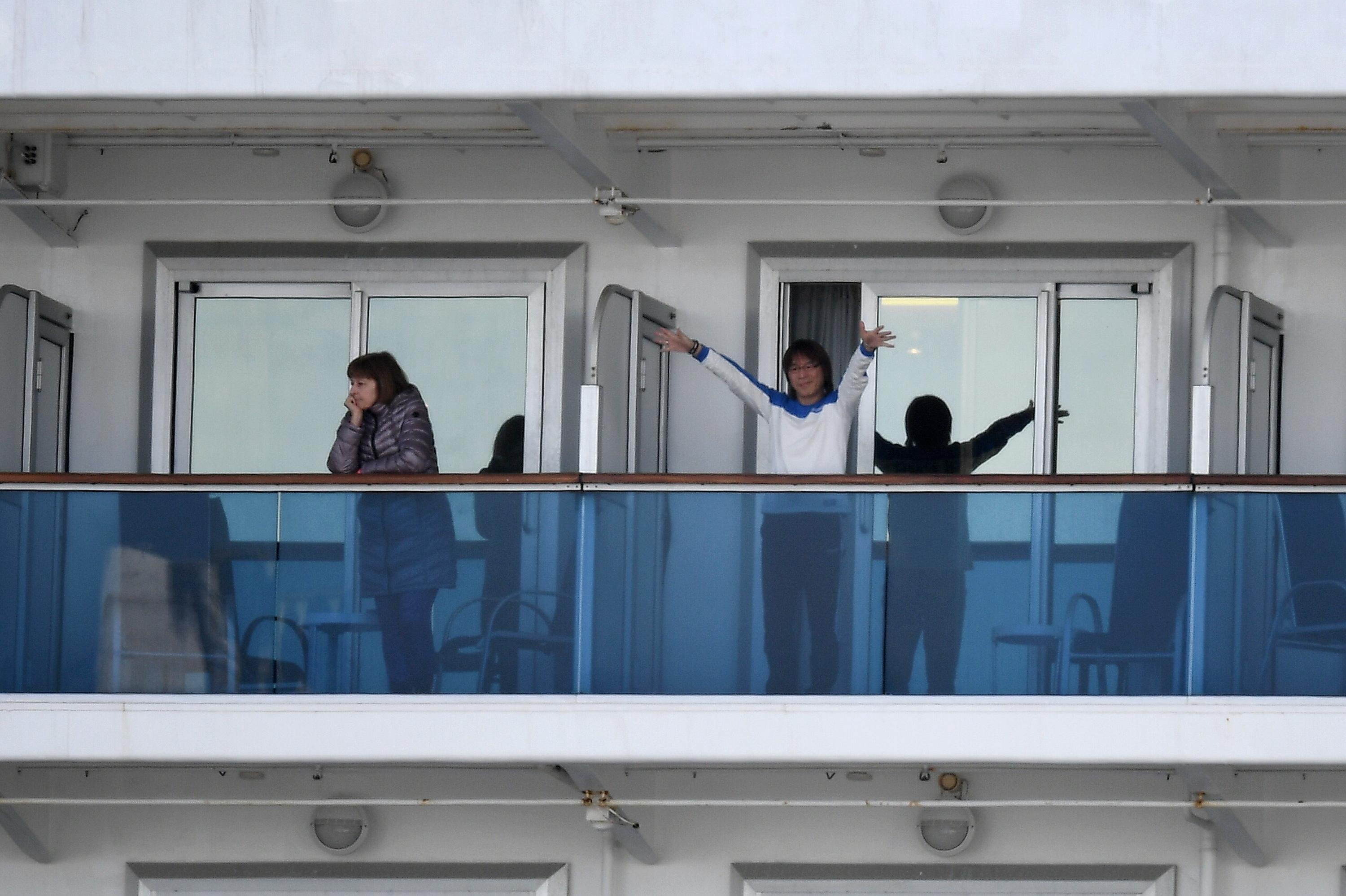 Passageiros acenam do navio "Diamond Princess"
