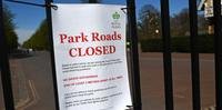 Um sinal anexado a grades do Greenwich Park explica as razões para o fechamento de estradas no parque de Londres