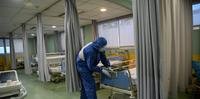 Um trabalhador de saúde limpa o departamento de emergência do Hospital Ramon y Cajal, em Madri, em 14 de abril