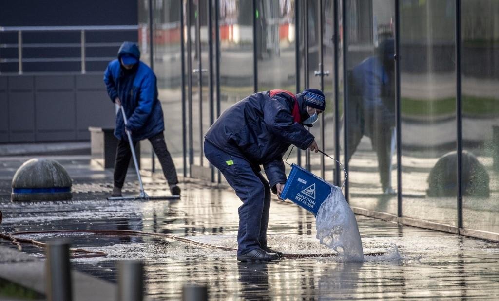 Trabalhadores desinfectam rua de Moscou