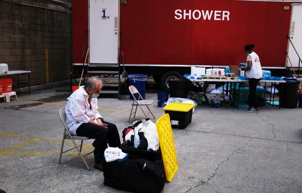 Morador em situa&ccedil;&atilde;o de vulnerabilidade social estadunidense aguarda a abertura de estrutura montada em Manhattan para tomar banho