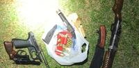 Uma pistola calibre 9 milímetros, uma espingarda calibre 12 e um revólver calibre 38, além de munição, faca, droga e dinheiro, foram apreendidos