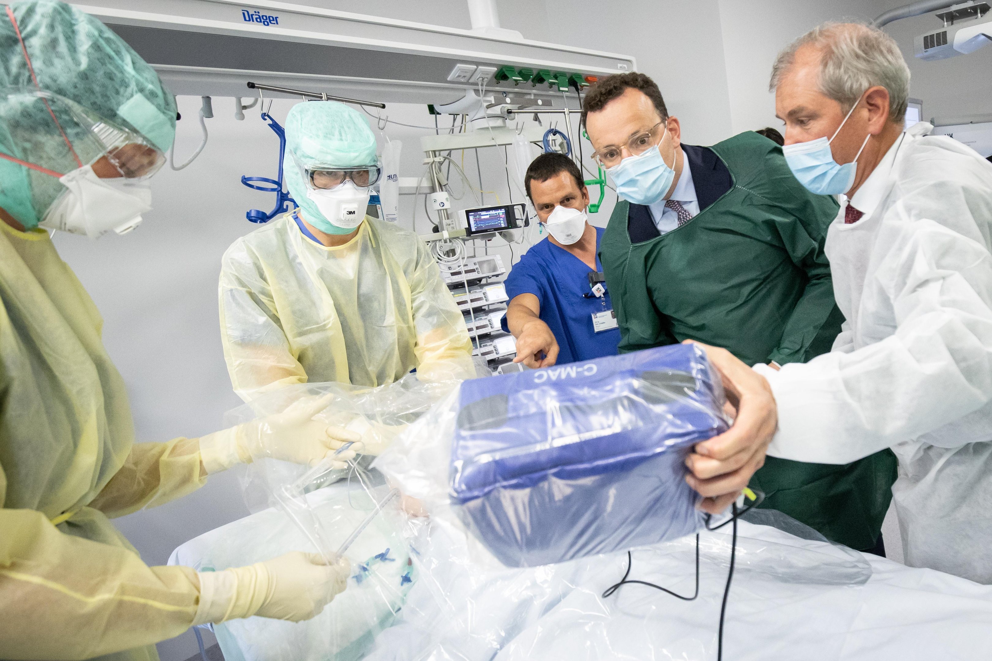 O Ministro da Sa&uacute;de alem&atilde;o, Jens Spahn, analisa um sistema de intuba&ccedil;&atilde;o para pacientes infectados com o coronav&iacute;rus ao lado do Presidente do Conselho do Centro M&eacute;dico Universit&aacute;rio de Schleswig-Holstein (UKSH), Jens Scholz, durante sua visita &agrave; unidade de terapia intensiva do UKSH