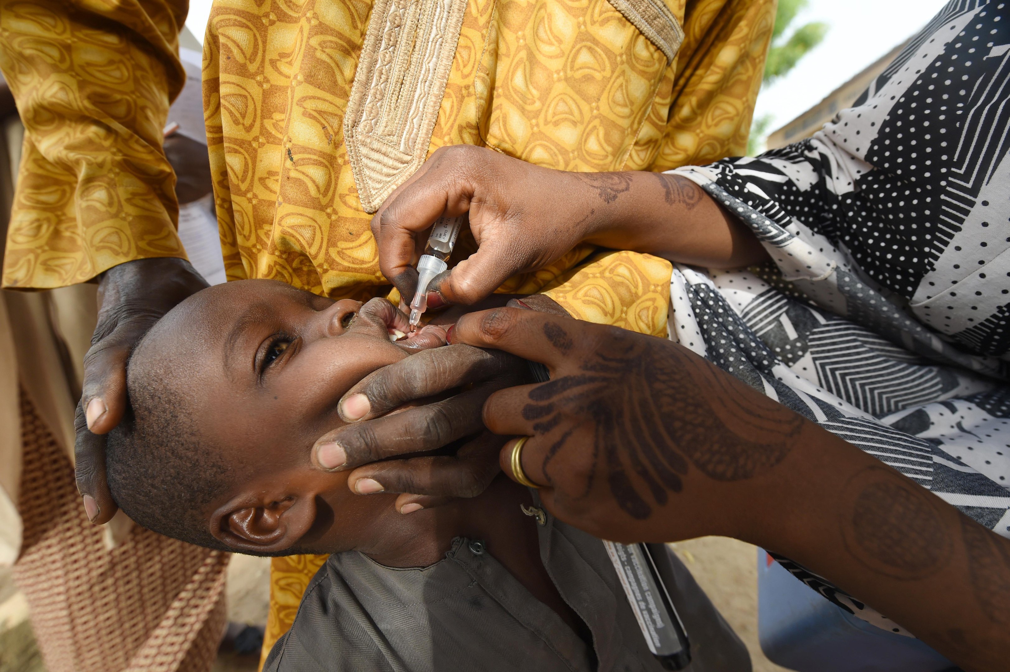 Um trabalhador de sa&uacute;de administra uma vacina a uma crian&ccedil;a durante uma campanha de vacina&ccedil;&atilde;o contra a poliomielite em Hotoro-Kudu, distrito de Nassarawa de Kano, no noroeste da Nig&eacute;ria