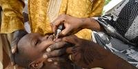 Um trabalhador de saúde administra uma vacina a uma criança durante uma campanha de vacinação contra a poliomielite em Hotoro-Kudu, distrito de Nassarawa de Kano, no noroeste da Nigéria