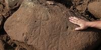 Foi encontrada também uma pedra em que estavam gravados personagens com chifres esticando seus braços