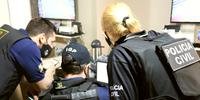 Policiais civis e peritos examinam computadores dos suspeitos em busca de provas