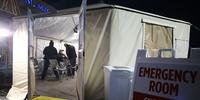 Médicos avaliam um paciente em uma tenda de triagem montada fora do Providence St. Mary Medical Center em meio a um surto no sul da Califórnia