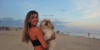 Camila Ribeiro e a dog Antônia, de 8 anos, na praia de Atlântida