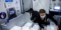 Funcionários colocam vacinas Pfizer-BioNtech COVID-19 em um freezer na fábrica da Pfizer em Puurs, Bélgica, em 22 de fevereiro
