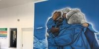 Foram quatro dias de trabalho para retratar o abraço num fundo azul e cercado por nuvens, pela visão do artista