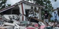 Pessoas vasculham destroços de casas destruídas pelo terremoto em Camp Perrin