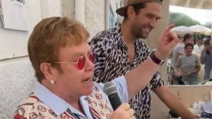 No v&iacute;deo, Elton John pede para o DJ do restaurante fazer uma pausa para que ele possa cantar uma nova m&uacute;sica dele