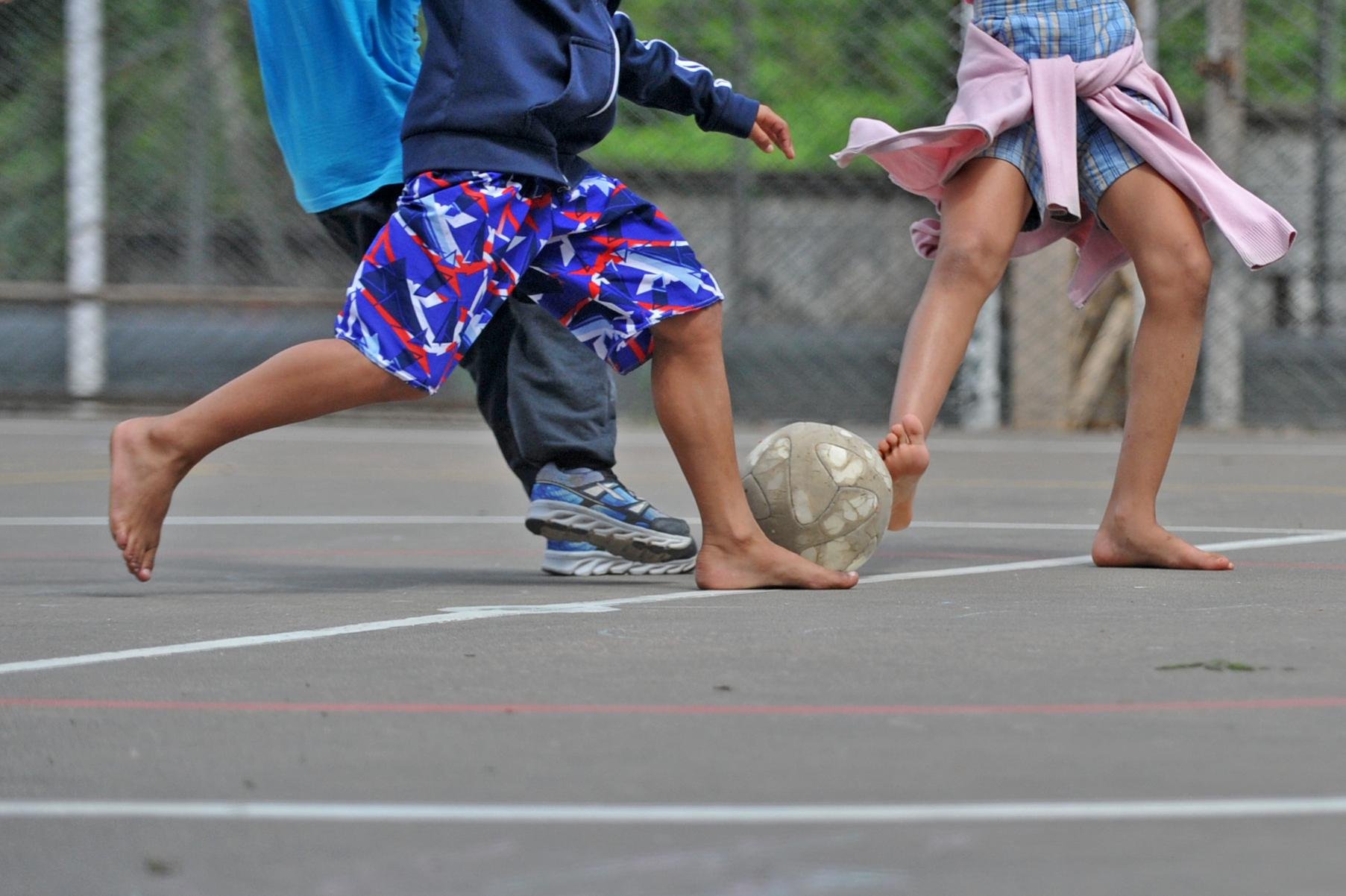 Partida de futebol entre crian&ccedil;as na escola.
