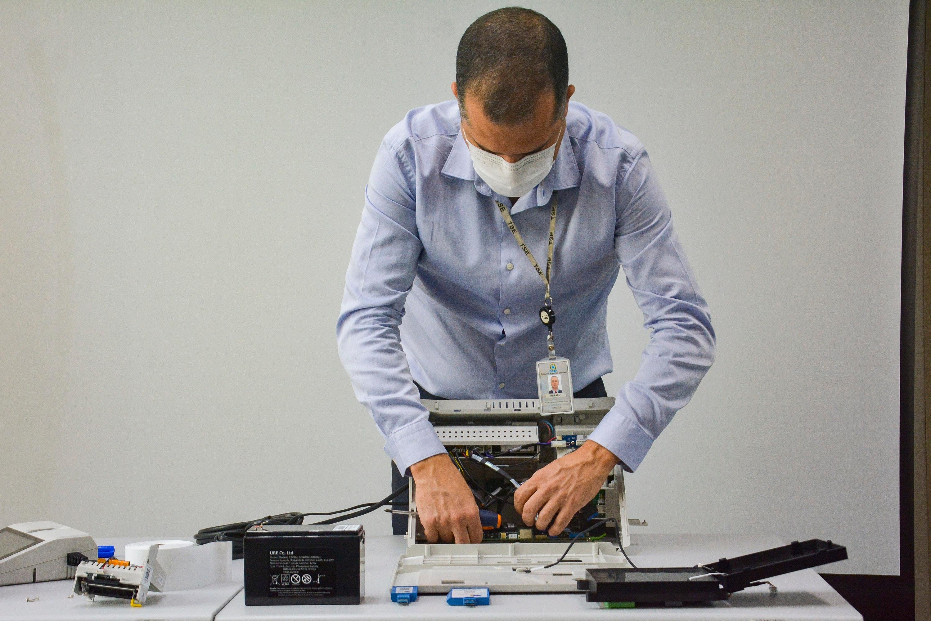O coordenador de tecnologia do TSE, Rafael Azevedo, abre uma urna eletr&ocirc;nica