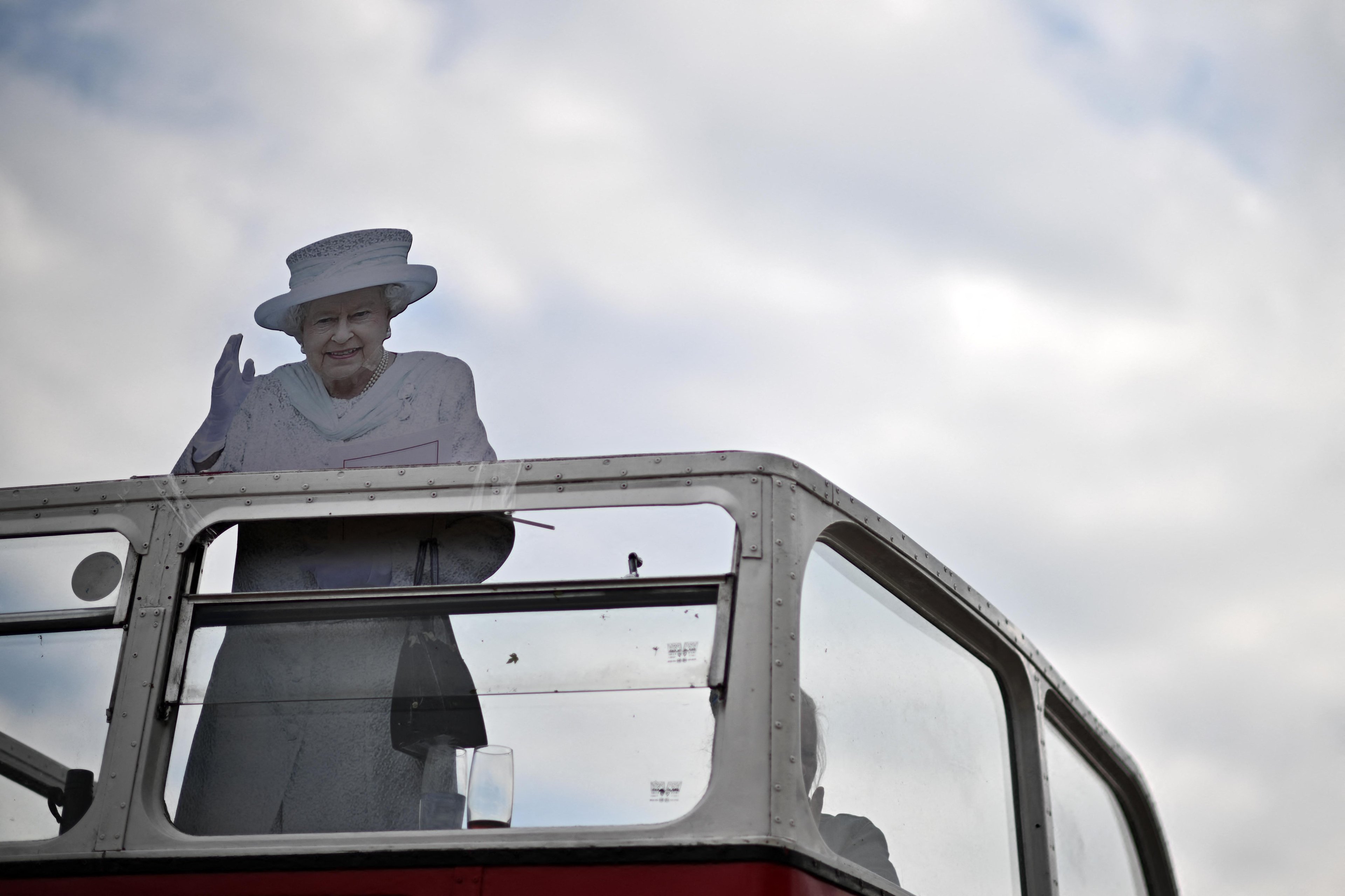 Uma imagem de papel&atilde;o da rainha Elizabeth II  faz uma apari&ccedil;&atilde;o na parte superior de um &ocirc;nibus no segundo dia da reuni&atilde;o de corrida de cavalos "Derby de Epsom Downs"