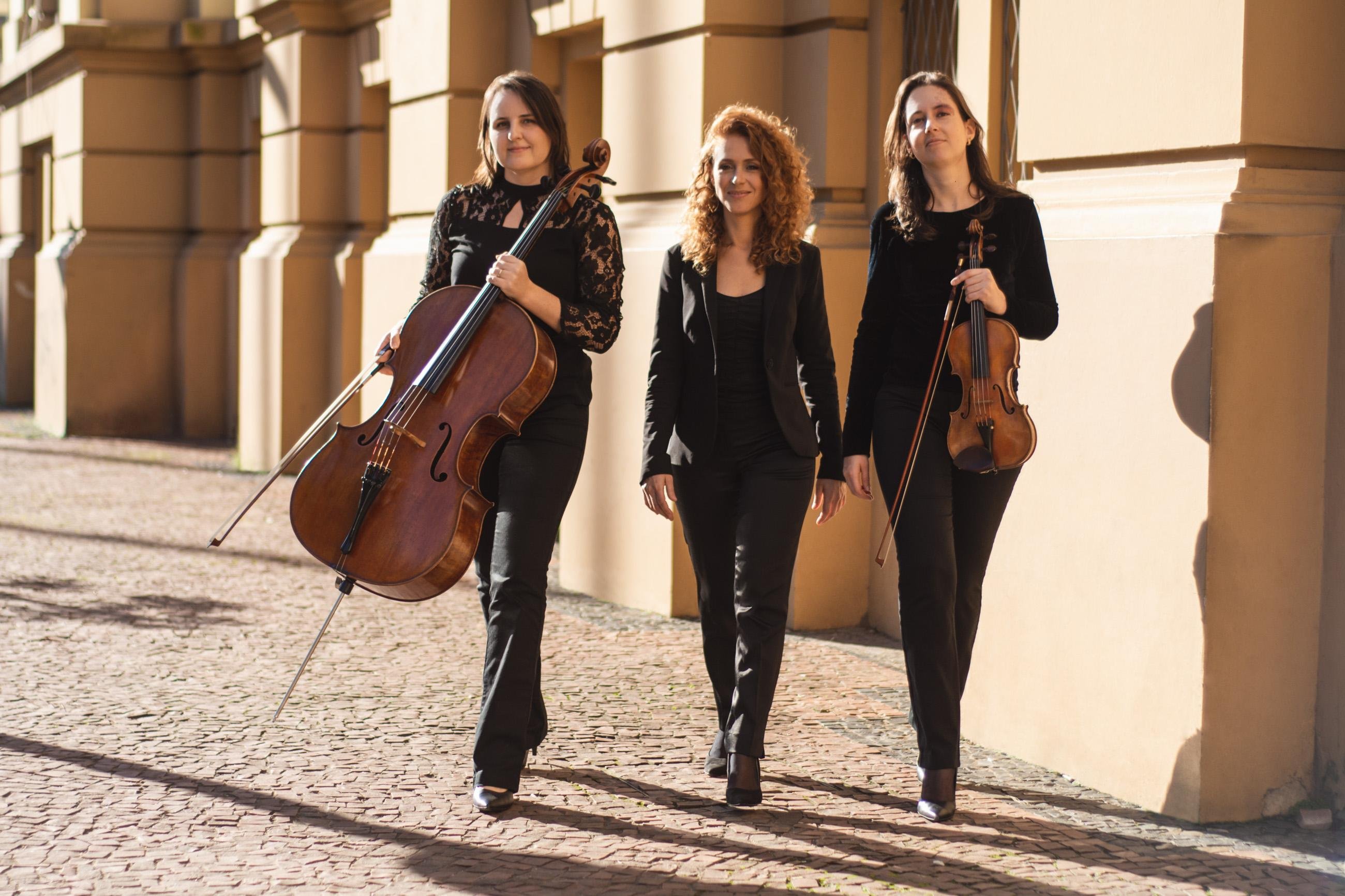 Brigitta Calloni (violino), Martina Str&ouml;her (violoncelo) e Liliana Michelsen (piano) se re&uacute;nem desde 2018 ocasionalmente para escolher repert&oacute;rio, ensaiar, conversar, mas uma s&eacute;rie de imprevistos, entre eles este per&iacute;odo de isolamento social imposto pela pandemia, as impediu de realizar o primeiro concerto juntas.