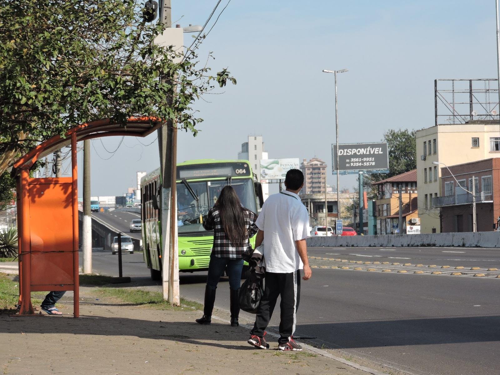 Passageiros aguardam &ocirc;nibus na parada