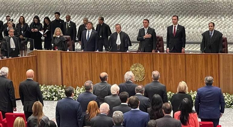 Moraes (&agrave; esquerda, de costas) e Bolsonaro (ao centro, na mesa), durante cerim&ocirc;nia no STJ