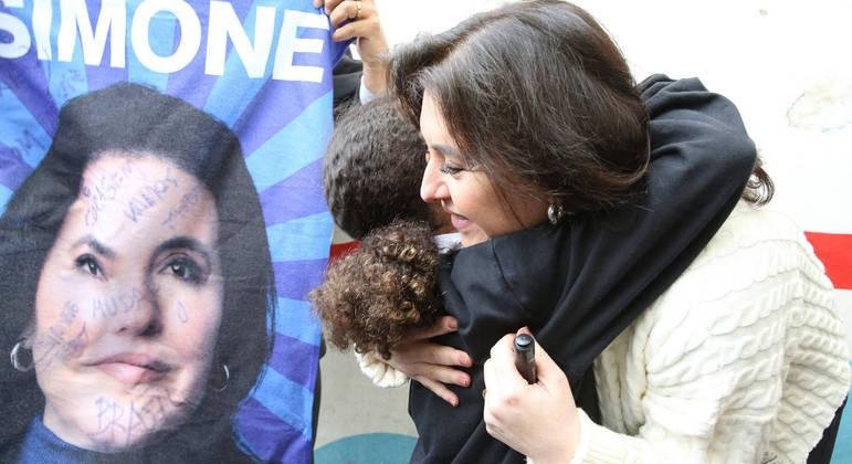 Simone Tebet, candidata do MDB &agrave; Presid&ecirc;ncia da Rep&uacute;blica, abran&ccedil;ando crian&ccedil;a