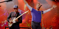 As pulseiras de led mudam a cor da luz que emitem conforme a música que o Coldplay toca no palco