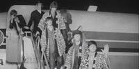 Os quatro cantores, vestidos de quimonos, saem do avião nas imagens