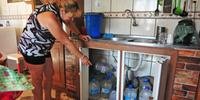 Dona de casa Delma Mello mostra as garrafas de água que acumula para driblar o desabastecimento