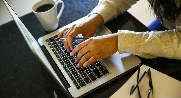 Mulher trabalha em computador; projeto de lei que facilita cr&eacute;dito &eacute; aprovado na C&acirc;mara